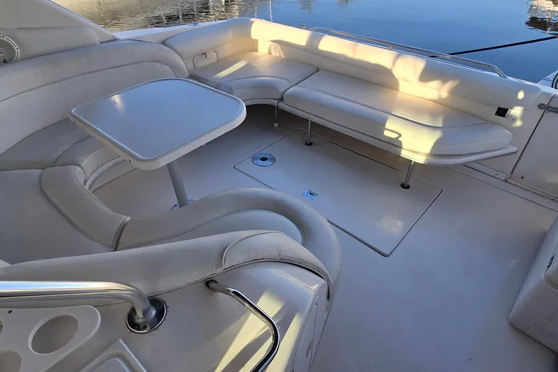 Slide: The Image of 1995 Sea Ray 450 Sundancer boat interior with cushioned seating and table. - 8