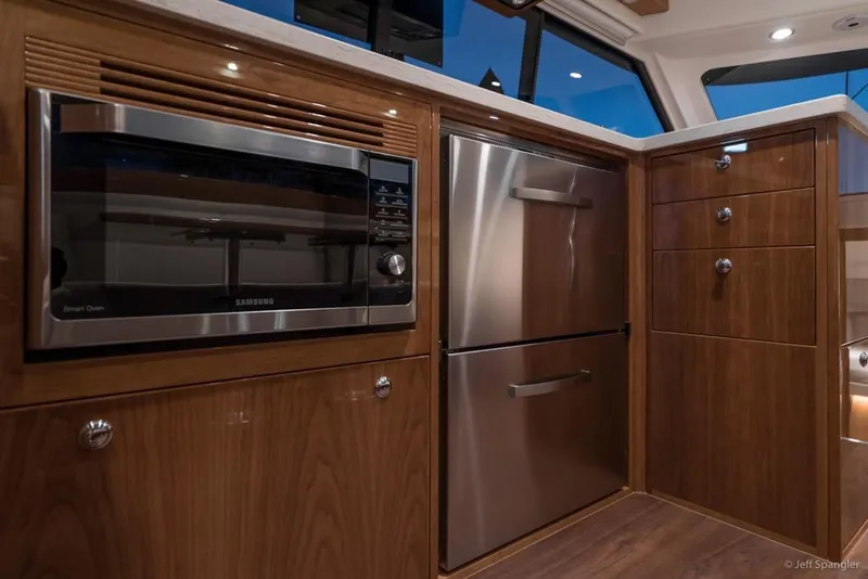 Slide: The Image of 2017 Riviera 43 Flybridge yacht interior with helm and white captain chairs. - 16