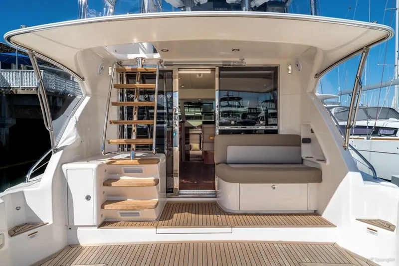 Slide: The Image of 2017 Riviera 43 Flybridge yacht on a blue transport trailer near a warehouse. - 42