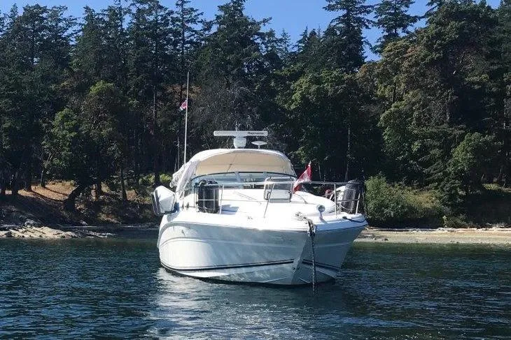 Slide: The Image of 2003 Sea Ray 360 Sundancer yacht anchored near a forested shoreline. - 3