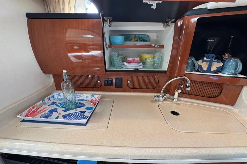 Slide: The Image of 2003 Sea Ray 360 Sundancer kitchen with wooden cabinets, sink, and colorful dishware. - 43