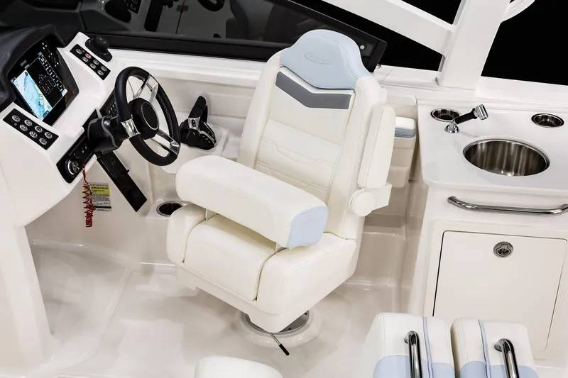 Slide: The Image of 2026 Robalo R257 Dual Console interior with helm, luxurious seating, and sink. - 17