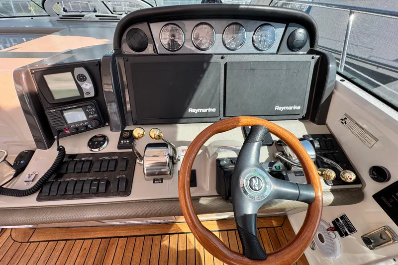Slide: The Image of Helm of 2006 Sea Ray 48 Sundancer with Raymarine electronics and wooden steering wheel. - 21