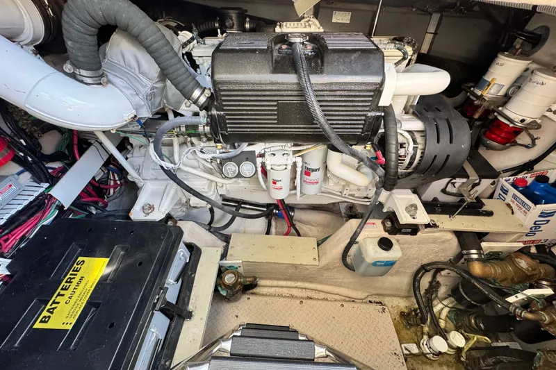 Slide: The Image of Engine room of 2006 Sea Ray 48 Sundancer with visible components and battery. - 26