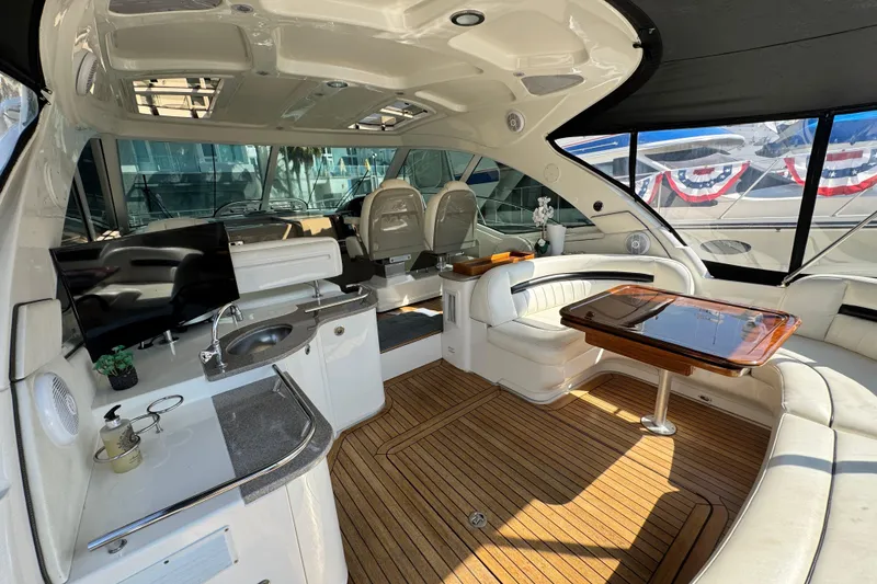 Slide: The Image of Luxurious interior of 2006 Sea Ray 48 Sundancer yacht with seating, table, and kitchenette. - 31
