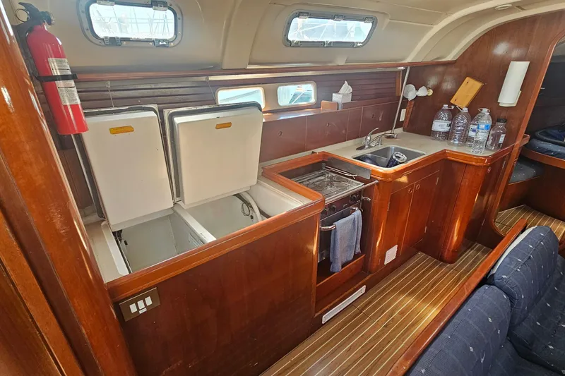 Slide: The Image of Interior of 1996 Beneteau Oceanis 440 yacht kitchen with wood finish and appliances. - 17