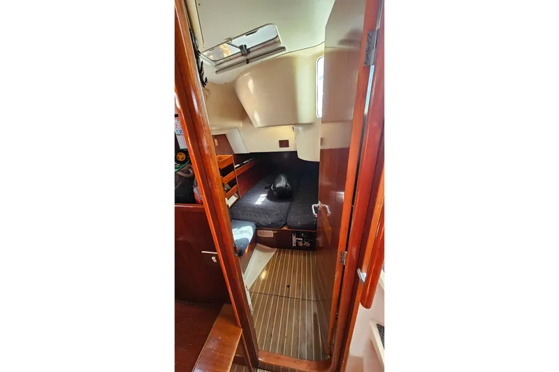 Slide: The Image of Interior cabin of 1996 Beneteau Oceanis 440 sailboat, featuring wooden finishes and cozy sleeping area. - 24