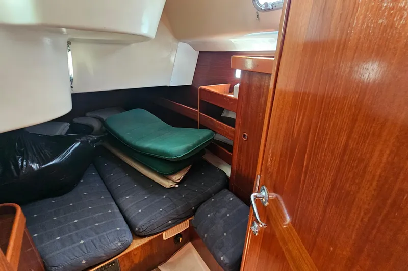 Slide: The Image of Interior cabin of 1996 Beneteau Oceanis 440 sailboat with wooden finish and cushions. - 31