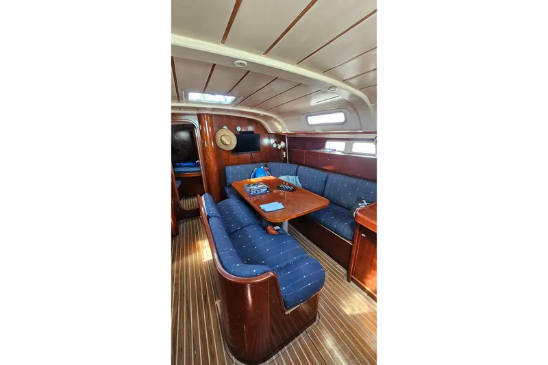 Slide: The Image of Interior of 1996 Beneteau Oceanis 440 yacht with blue seating and wooden table. - 36