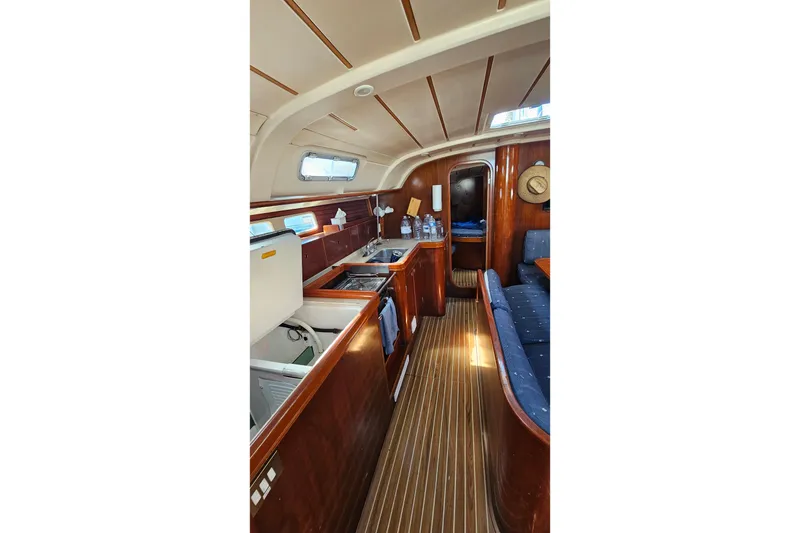 Slide: The Image of Interior of 1996 Beneteau Oceanis 440 yacht with wooden cabinetry and seating area. - 37