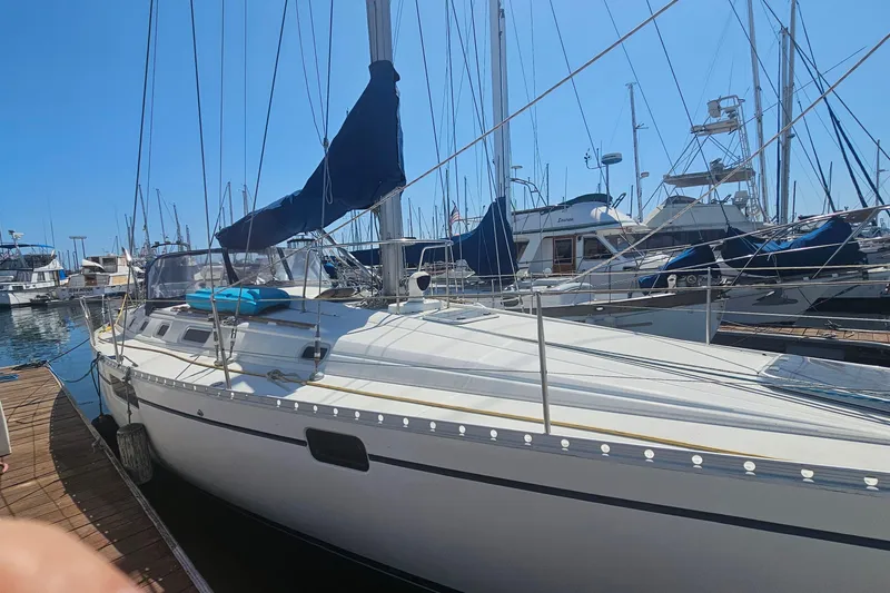 Slide: The Image of 1996 Beneteau Oceanis 440 sailboat docked at a marina under clear blue skies. - 4