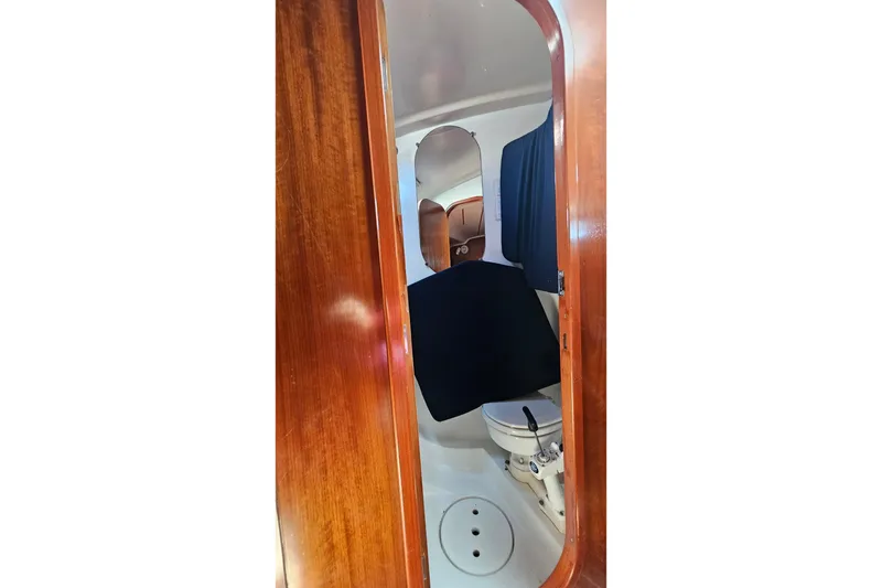 Slide: The Image of Interior view of 1996 Beneteau Oceanis 440 yacht bathroom with wooden door and marine toilet. - 40