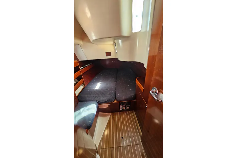 Slide: The Image of 1996 Beneteau Oceanis 440 cabin interior with wooden finish and cozy sleeping area. - 44