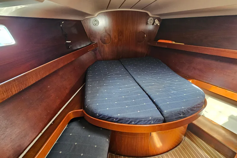 Slide: The Image of 1996 Beneteau Oceanis 440 cabin interior with wooden finish and blue mattress. - 49