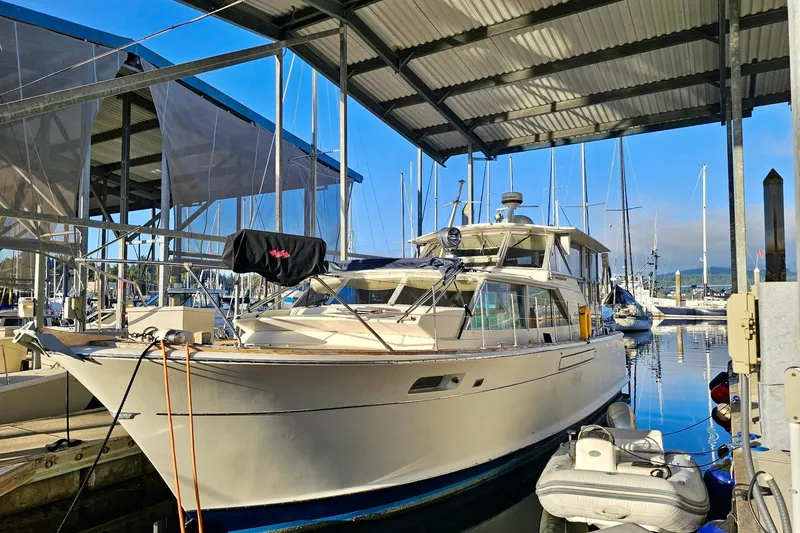 The Image of 1970 Chris-Craft Commander 42 docked in a marina under a covered shelter. - 0