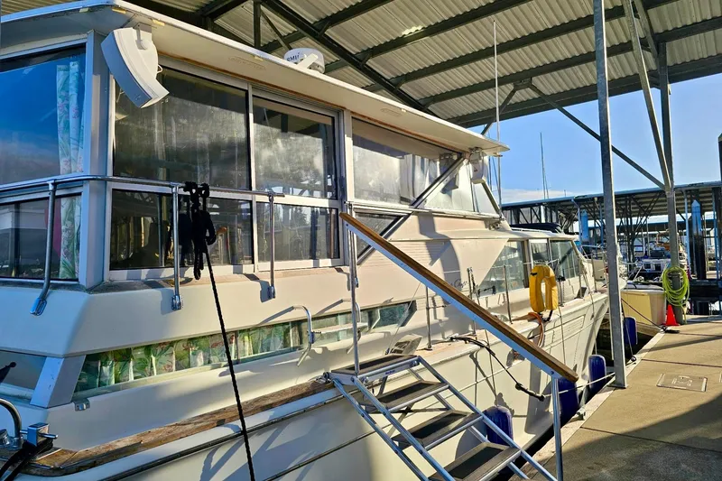 Slide: The Image of 1970 Chris-Craft Commander 42 yacht docked in a marina under a covered structure. - 11