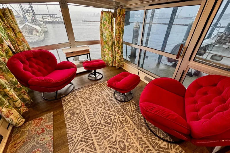 Slide: The Image of 1970 Chris-Craft Commander 42 interior with vibrant red chairs, floral curtains, and waterfront view. - 12