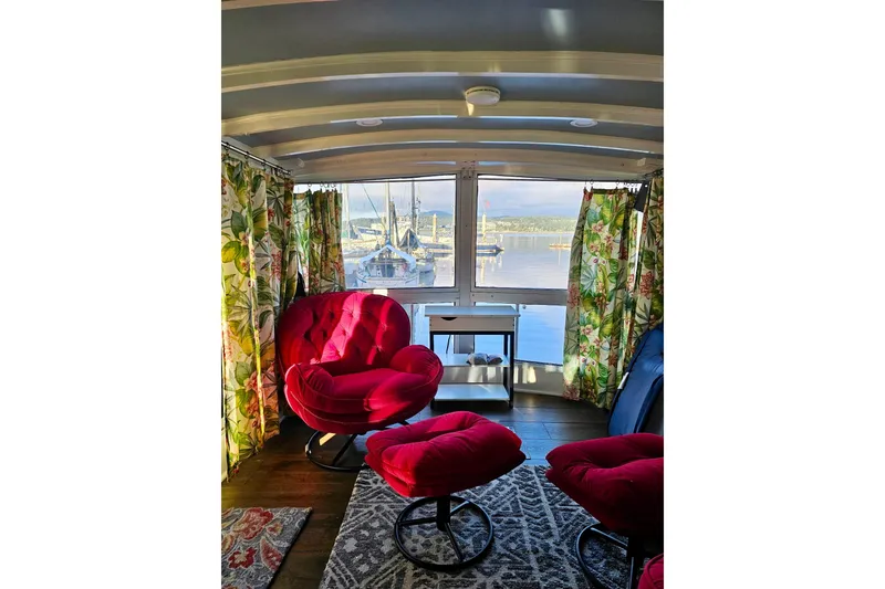 Slide: The Image of Interior of 1970 Chris-Craft Commander 42 with red chairs, floral curtains, and marina view. - 13