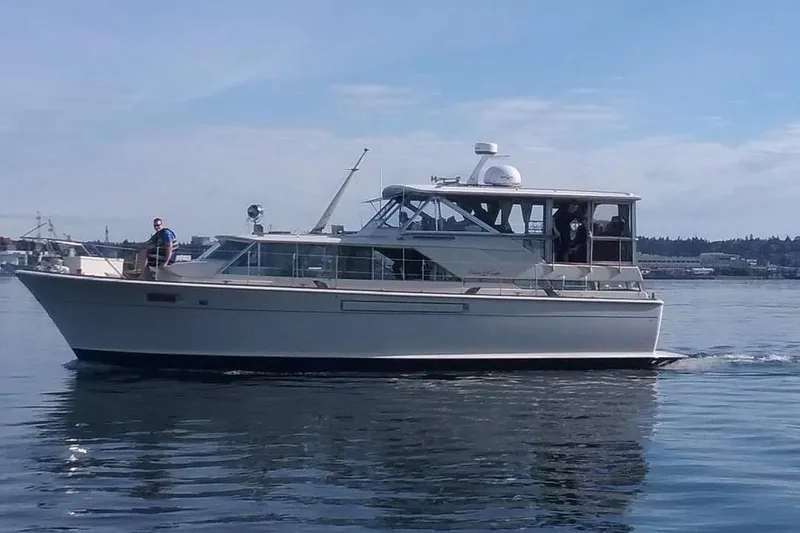 Slide: The Image of 1970 Chris-Craft Commander 42 yacht cruising on calm waters under a clear sky. - 2
