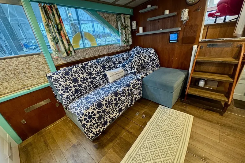 Slide: The Image of Interior of 1970 Chris-Craft Commander 42 with patterned sofa, wooden flooring, and nautical decor. - 30