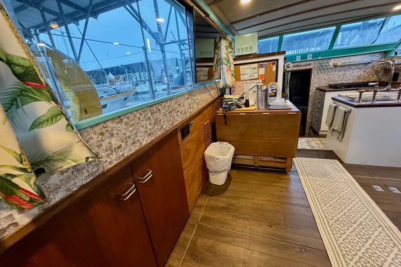 Slide: The Image of 1970 Chris-Craft Commander 42 interior with wood cabinetry, large windows, and nautical decor. - 33