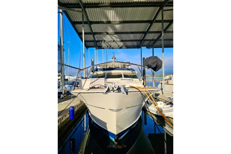 Slide: The Image of 1970 Chris-Craft Commander 42 docked under a covered marina, front view. - 4