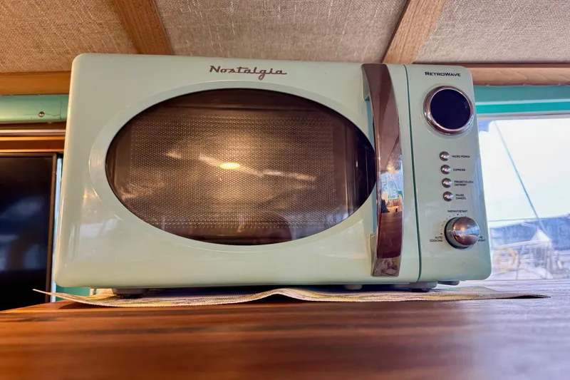 Slide: The Image of Retro-style microwave oven on a wooden surface inside a 1970 Chris-Craft Commander 42. - 43