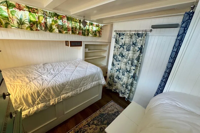 Slide: The Image of 1970 Chris-Craft Commander 42 cabin interior with cozy bedding and floral curtains. - 47
