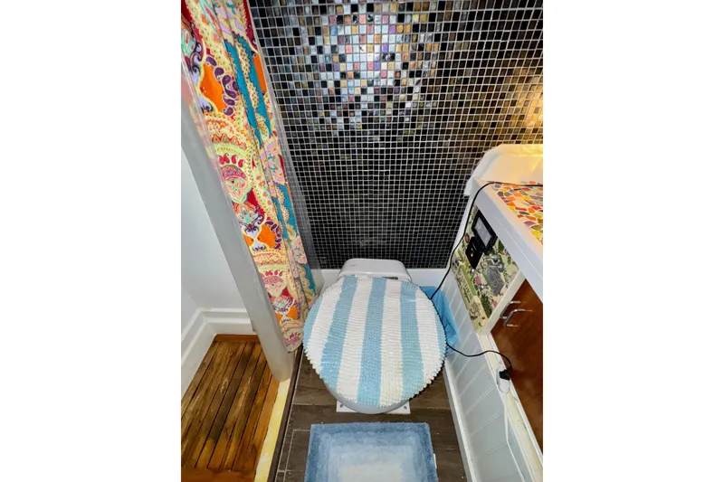 Slide: The Image of 1970 Chris-Craft Commander 42 bathroom with mosaic tiles and colorful shower curtain. - 53