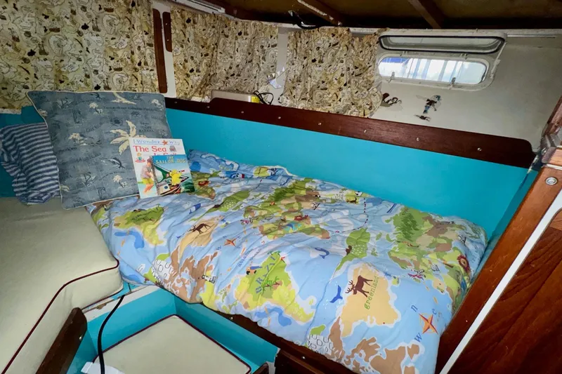 Slide: The Image of Cozy cabin interior of 1970 Chris-Craft Commander 42 with map-themed bedding and nautical decor. - 55