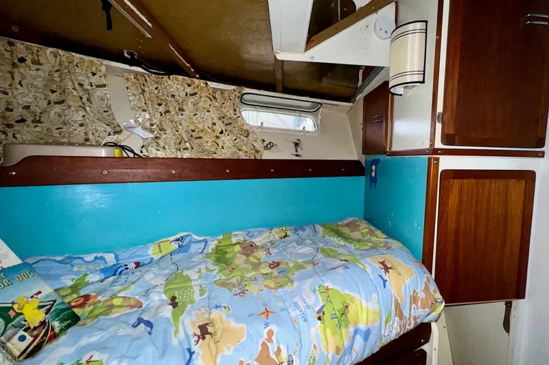 Slide: The Image of 1970 Chris-Craft Commander 42 cabin interior with map-themed bedding and wooden cabinets. - 58