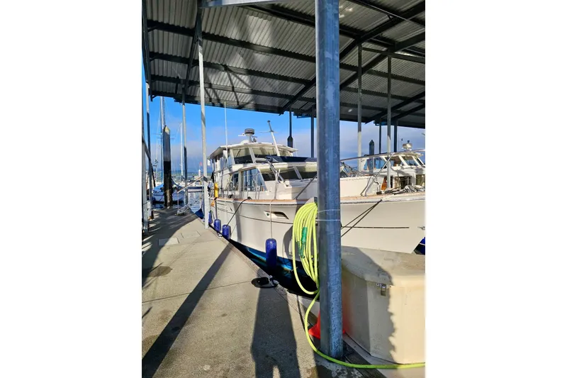 Slide: The Image of 1970 Chris-Craft Commander 42 docked under a covered marina, with visible mooring equipment. - 67