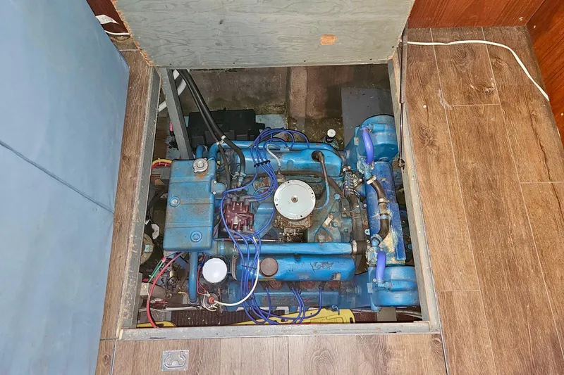 Slide: The Image of 1970 Chris-Craft Commander 42 engine compartment with visible blue machinery and wooden flooring. - 72