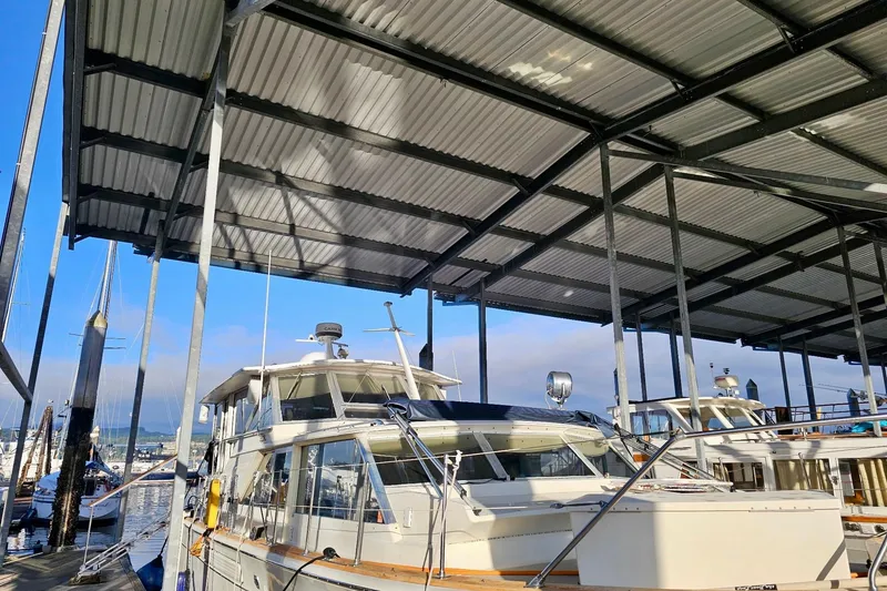 Slide: The Image of 1970 Chris-Craft Commander 42 docked under a metal canopy at a marina. - 75