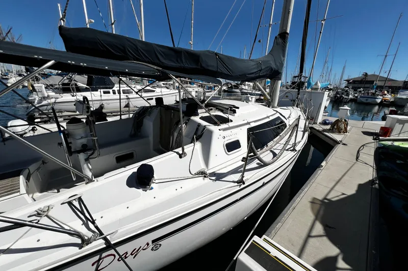 Slide: The Image of 1989 Hunter Vision 32 sailboat docked at marina, surrounded by other boats under clear blue sky. - 11