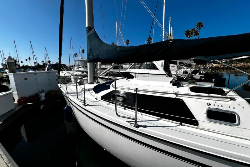 Slide: The Image of 1989 Hunter Vision 32 sailboat docked in a sunny marina. - 13