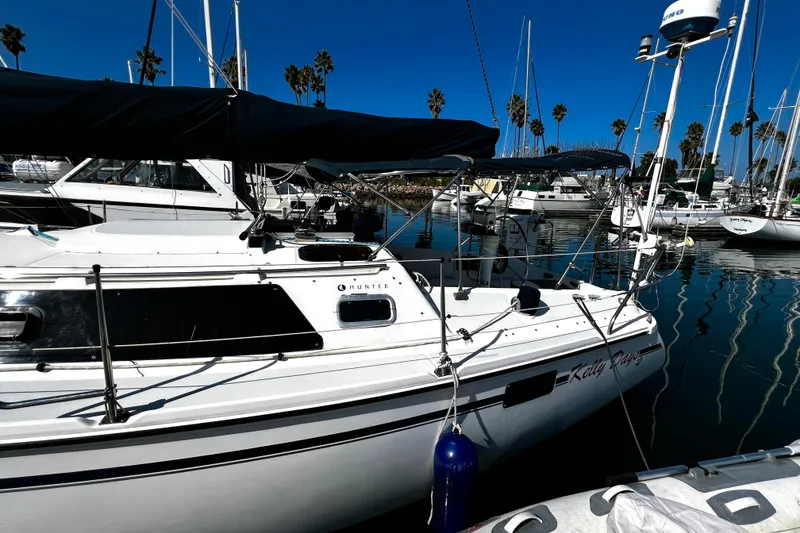 Slide: The Image of Sailboat Hunter Vision 32, 1989 model, docked in a marina with clear blue skies. - 14