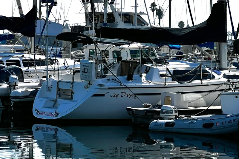 Slide: The Image of Hunter Vision 32 sailboat from 1989 docked in a marina, surrounded by other boats. - 17