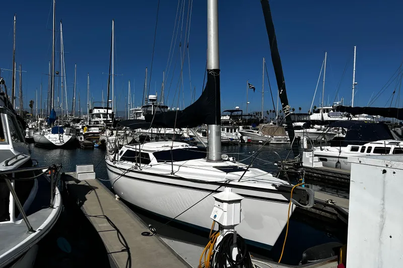 Slide: The Image of 1989 Hunter Vision 32 sailboat docked in a marina, surrounded by other boats. - 2
