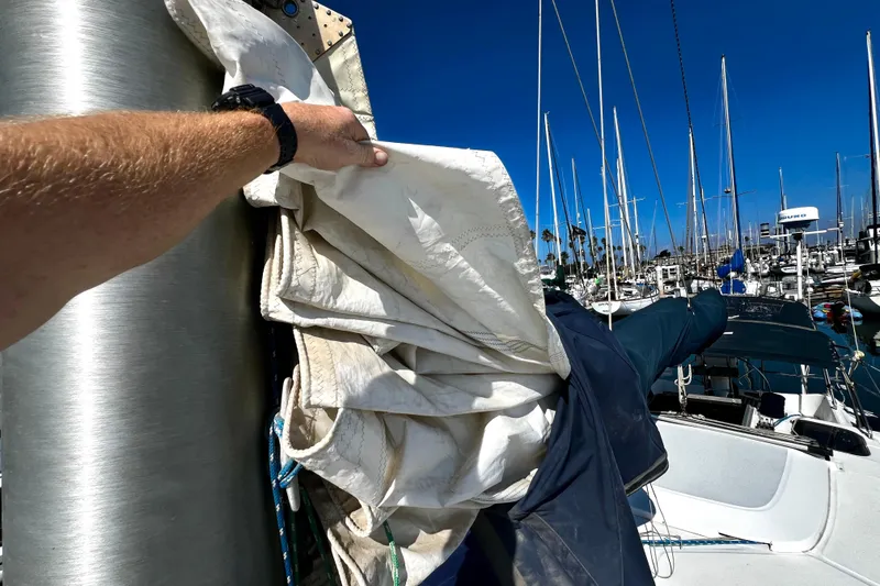 Slide: The Image of Person handling sail on 1989 Hunter Vision 32 yacht in marina. - 21