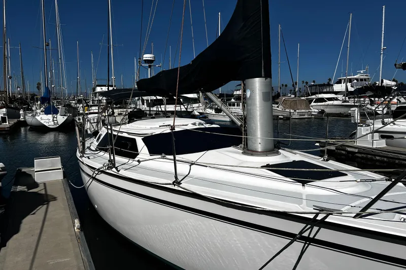 Slide: The Image of 1989 Hunter Vision 32 sailboat docked in a marina, surrounded by other boats. - 3
