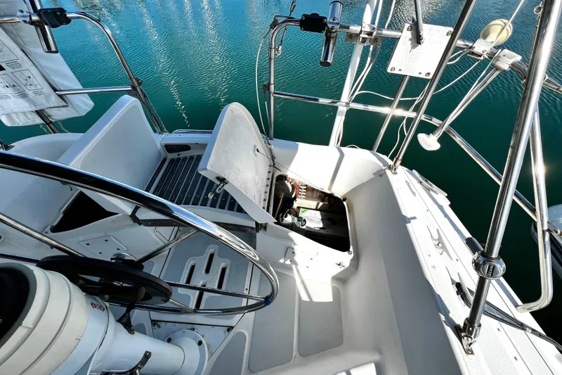 Slide: The Image of 1989 Hunter Vision 32 sailboat cockpit with open hatch, steering wheel, and marina view. - 31