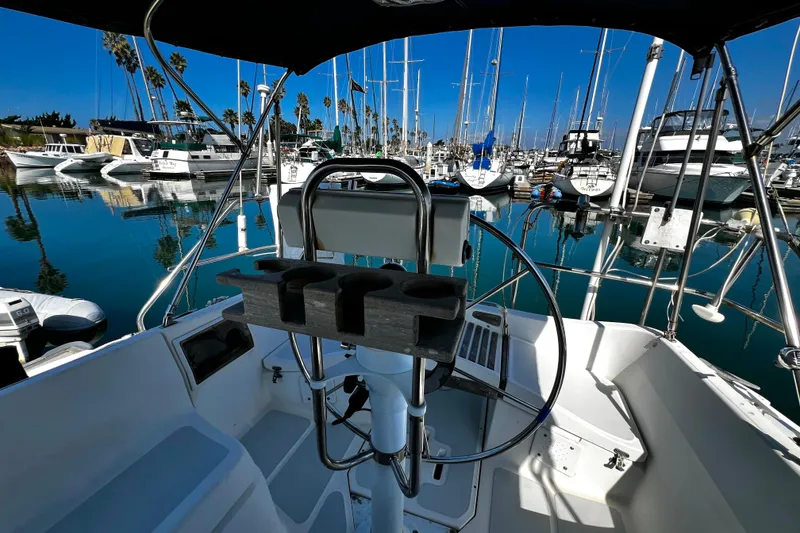 Slide: The Image of Cockpit view of 1989 Hunter Vision 32 sailboat in a marina with clear blue skies. - 33