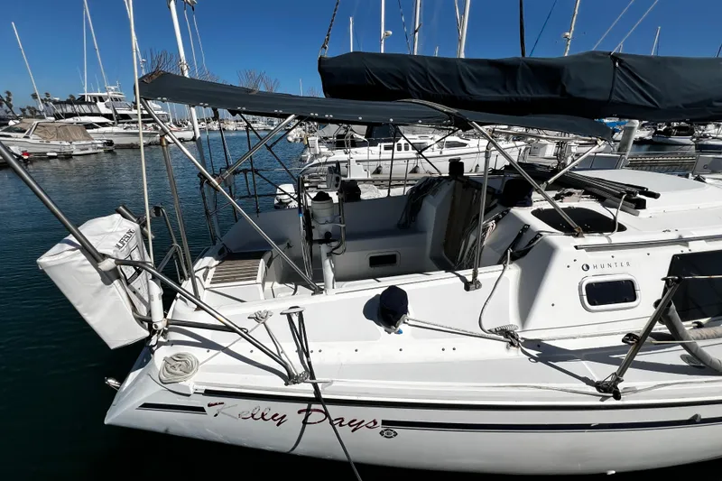 Slide: The Image of 1989 Hunter Vision 32 sailboat docked in marina, featuring sleek design and covered cockpit. - 4