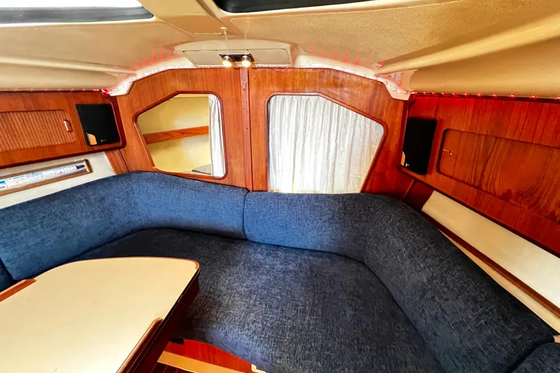 Slide: The Image of Cozy interior of 1989 Hunter Vision 32 sailboat with blue seating and wooden accents. - 46