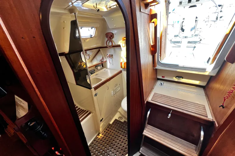 Slide: The Image of Interior of 1989 Hunter Vision 32 sailboat, featuring compact bathroom and wooden cabinetry. - 49