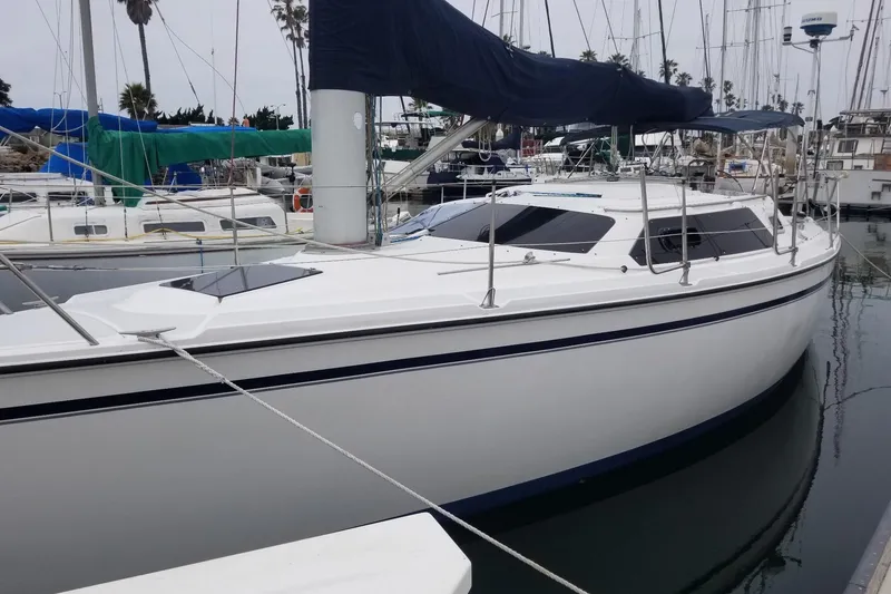 Slide: The Image of 1989 Hunter Vision 32 sailboat docked in marina, featuring sleek white hull and blue accents. - 5