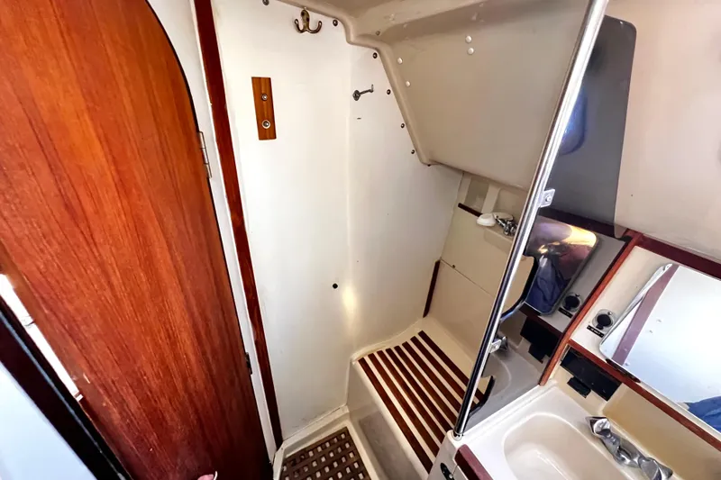 Slide: The Image of 1989 Hunter Vision 32 yacht bathroom with wooden accents and compact design. - 52
