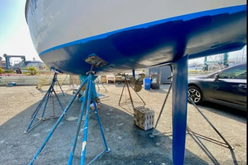 Slide: The Image of 1989 Hunter Vision 32 sailboat on stands, undergoing maintenance in a shipyard. - 63