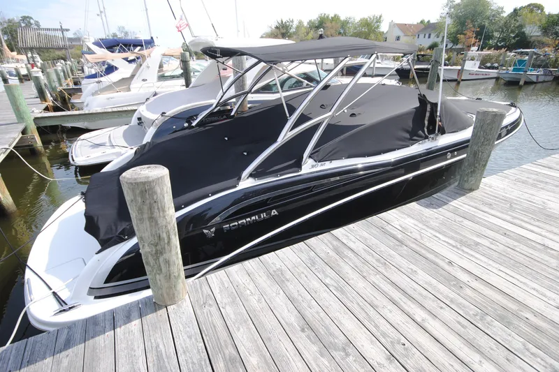 The Image of 2015 Formula 310 Bowrider boat docked with black cover and canopy. - 0